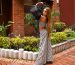 Woman in a chic black and white outfit posing stylishly in a vibrant outdoor setting.